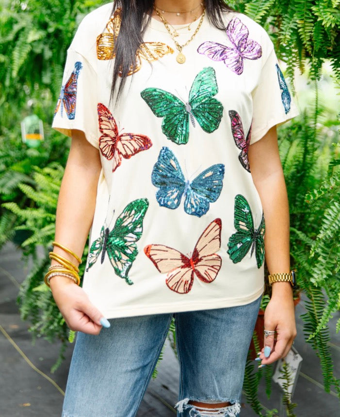RJM Glitz Butterfly Bliss sequin tee featuring colorful butterfly design and shiny sequin embellishments on soft fabric.