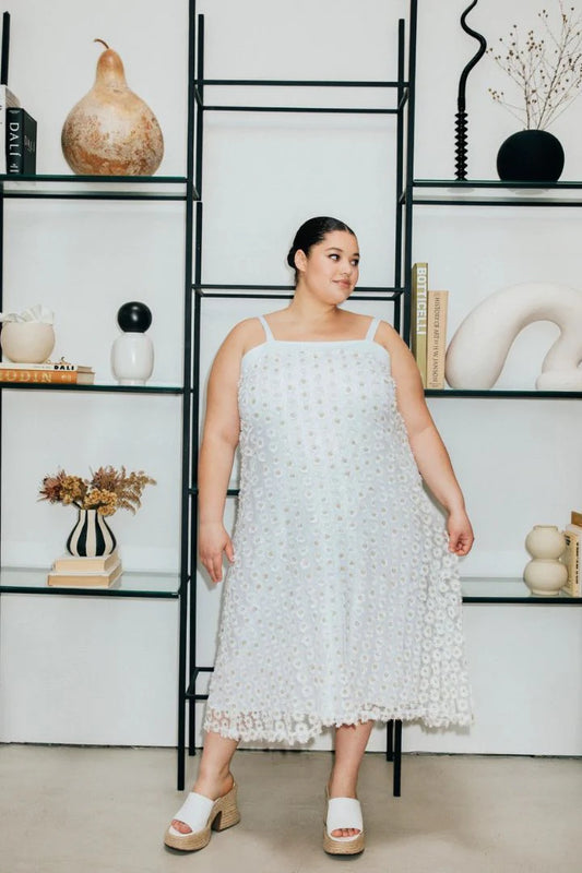 Textured Daisy Dress by Hilary MacMillan, featuring a floral pattern and fitted silhouette, displayed on a hanger.