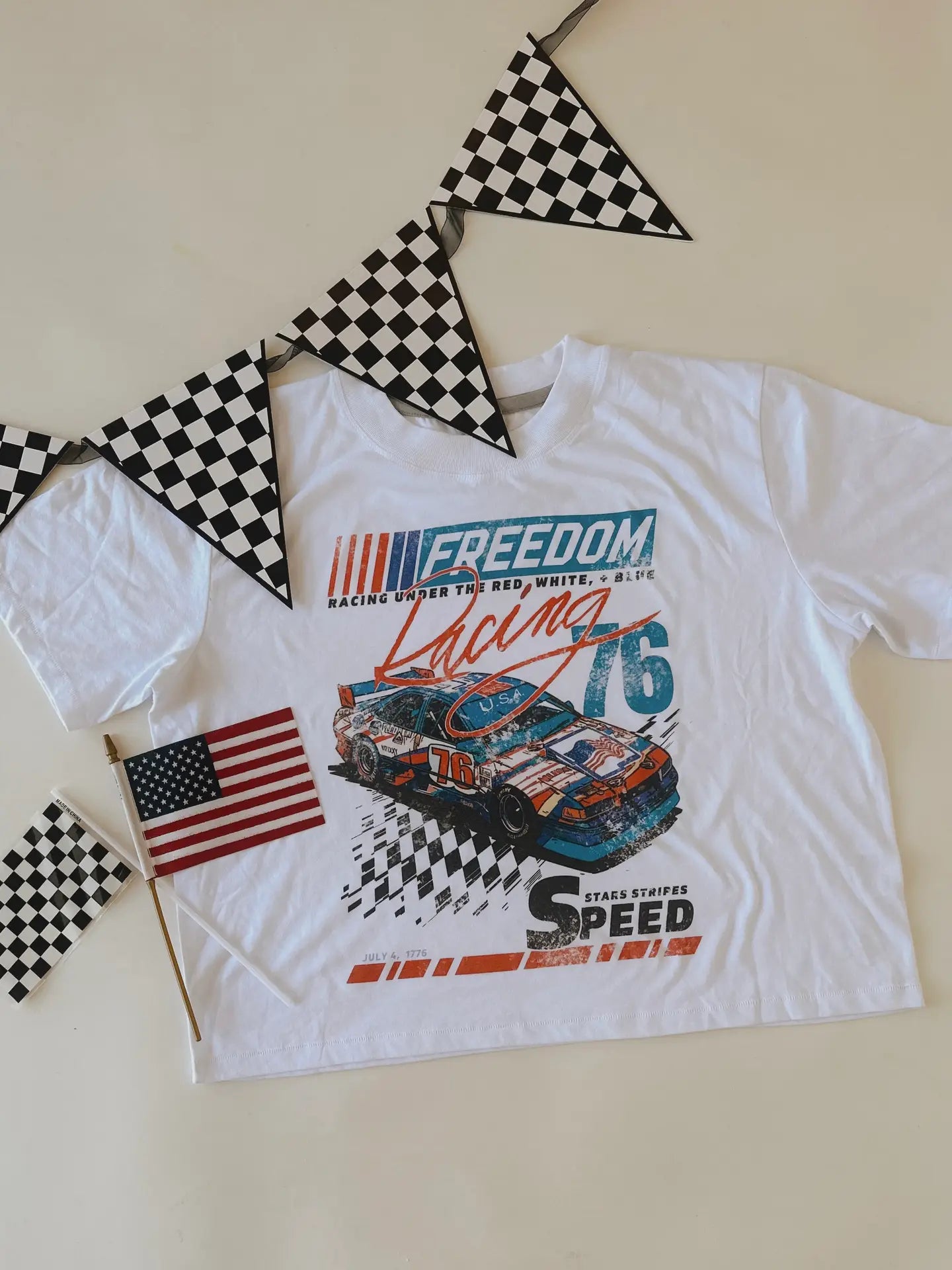 Stars, stripes, and speed design on Chaudoin Creations cropped T-shirt featuring patriotic patterns and bold graphics.