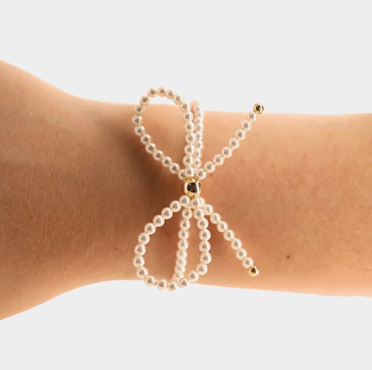 Beaded blond pearl bow bracelet featuring delicate pearl beads and a elegant bow charm from Beaded Blondes