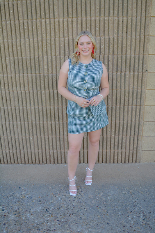 Entro Sweet Celebration Gingham Romper displayed on a hanger, featuring a classic red and white gingham pattern and sleeveless design.