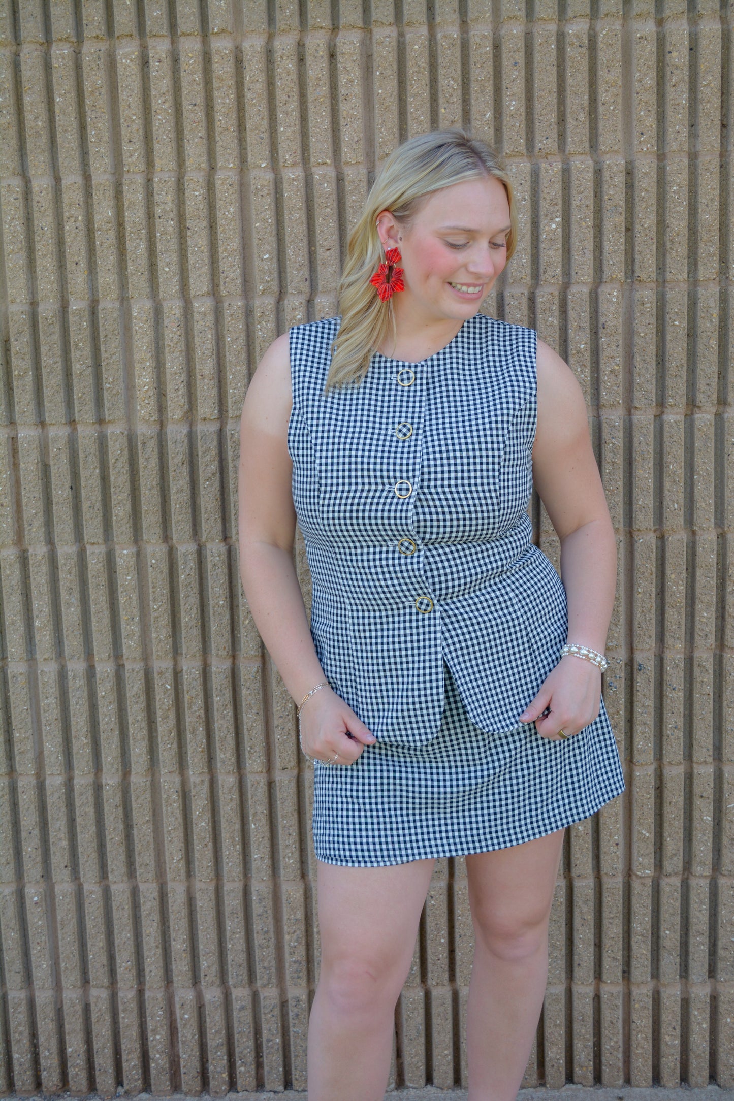 Entro Sweet Celebration Gingham Romper displayed on a hanger, featuring red and white gingham fabric with a sleeveless design.