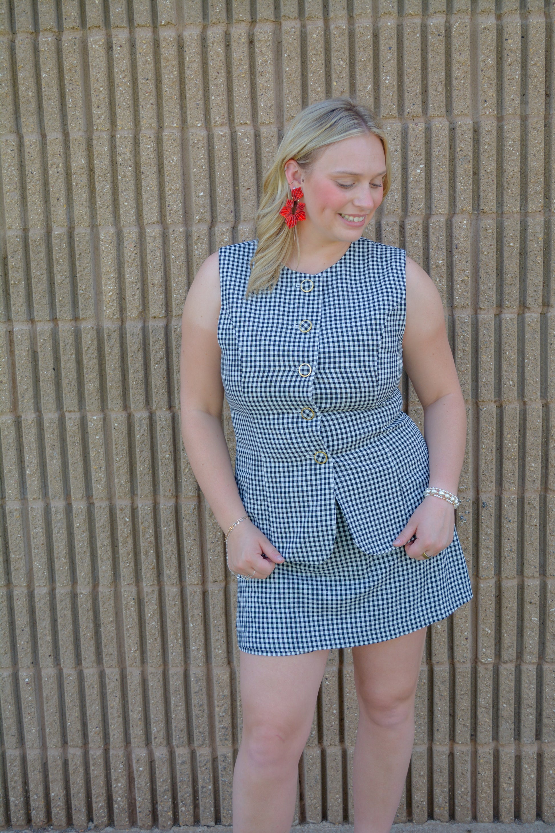 Entro Sweet Celebration Gingham Romper displayed on a hanger, featuring red and white gingham fabric with a sleeveless design.
