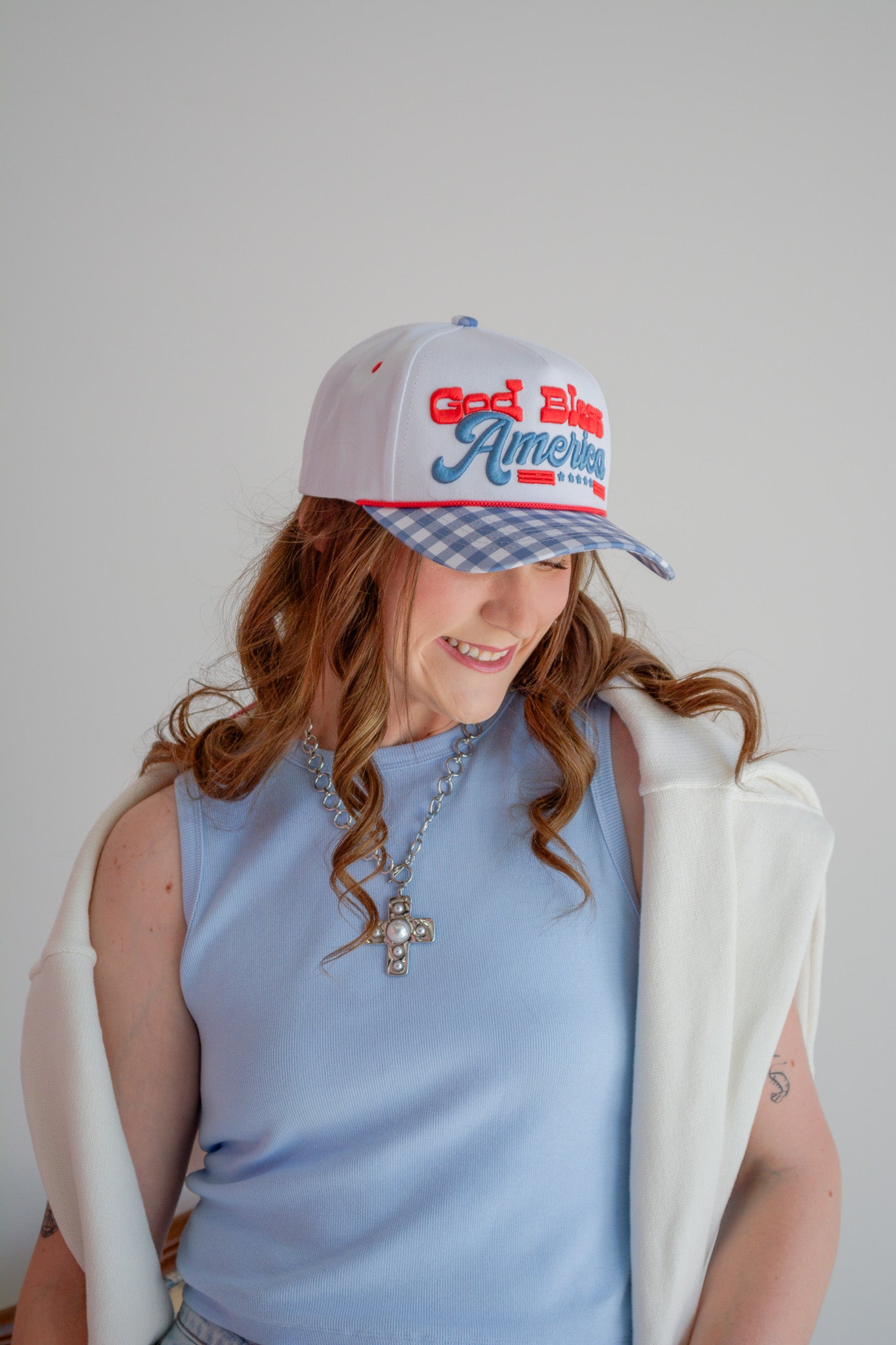 Red baseball cap with "God Bless America" embroidered in white, casual summer hat from Summer Tees.