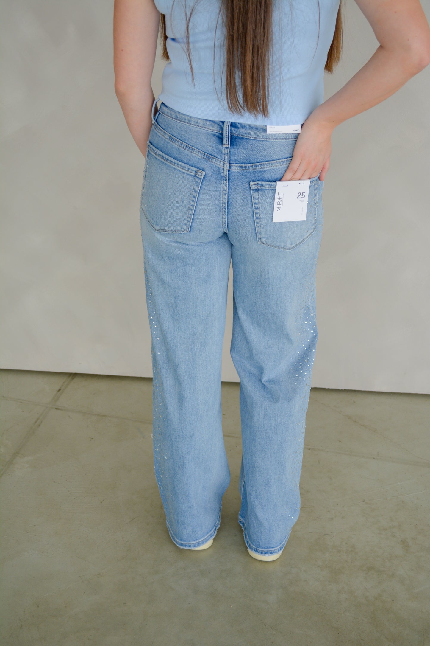Vervet Glam wide-leg jeans with high waist and distressed details, shown on a model in a casual setting.