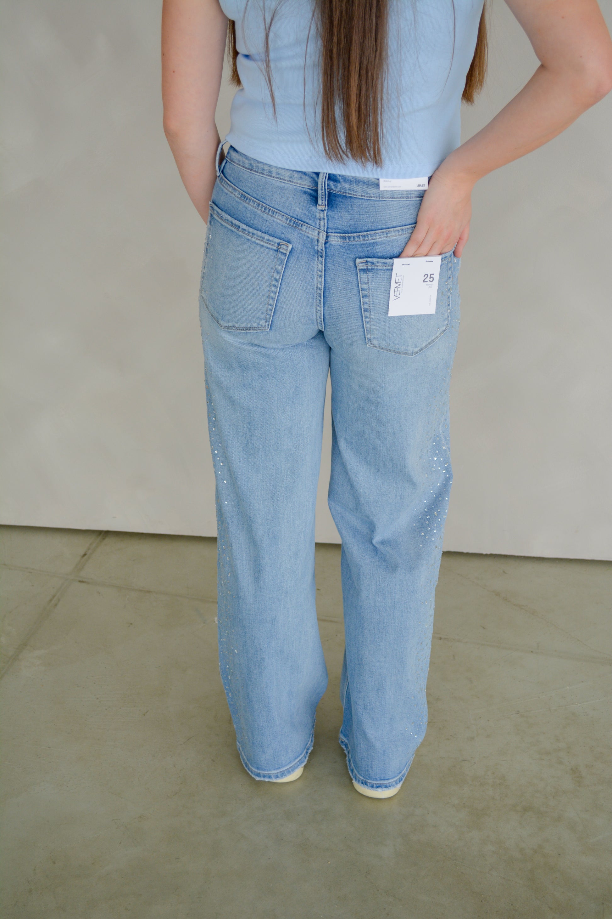 Vervet Glam wide-leg jeans with high waist and distressed details, shown on a model in a casual setting.