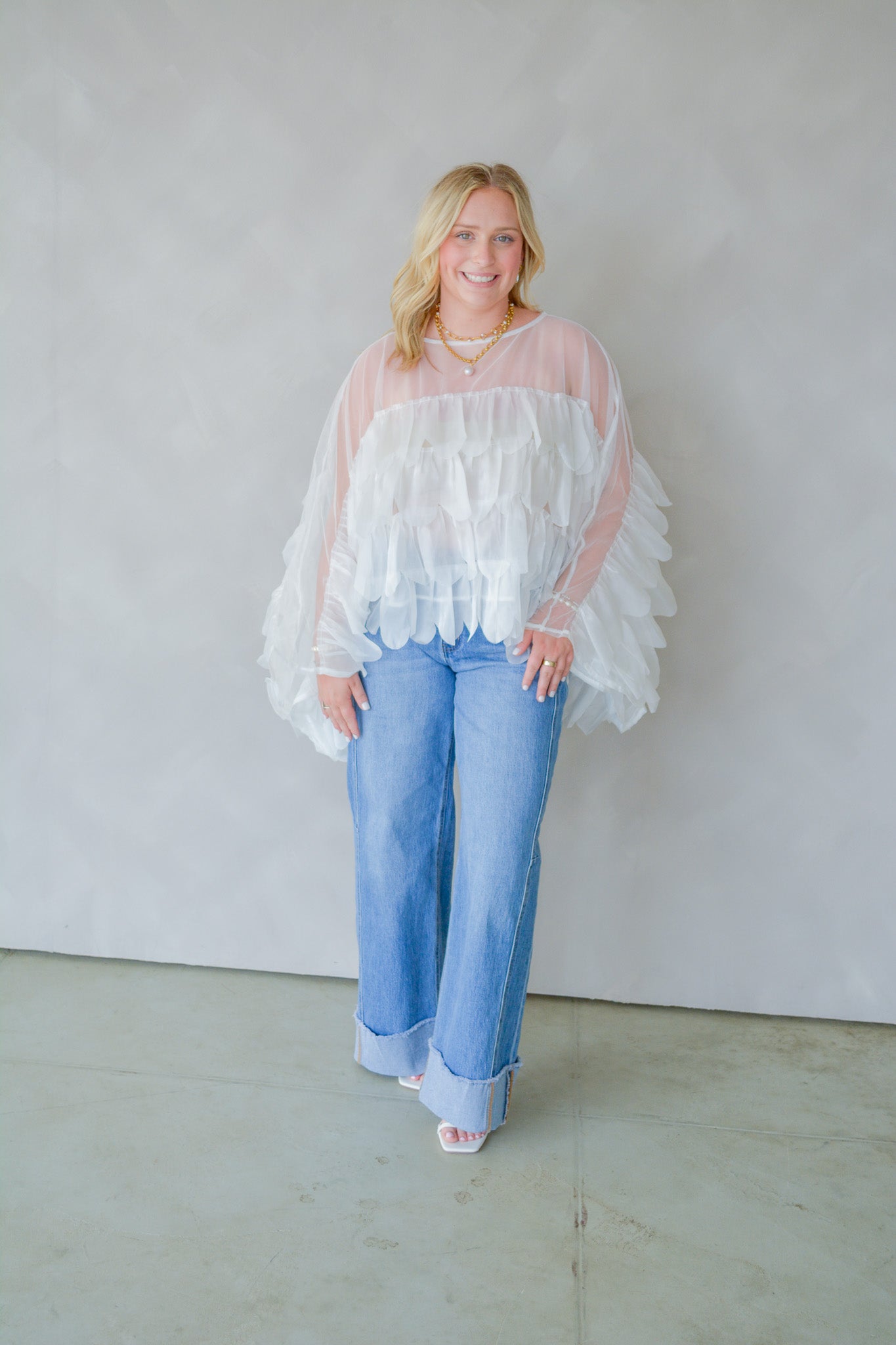 INA Pure Romance Ruffle Top, white sleeveless blouse with ruffle details, displayed hanging on a hanger.