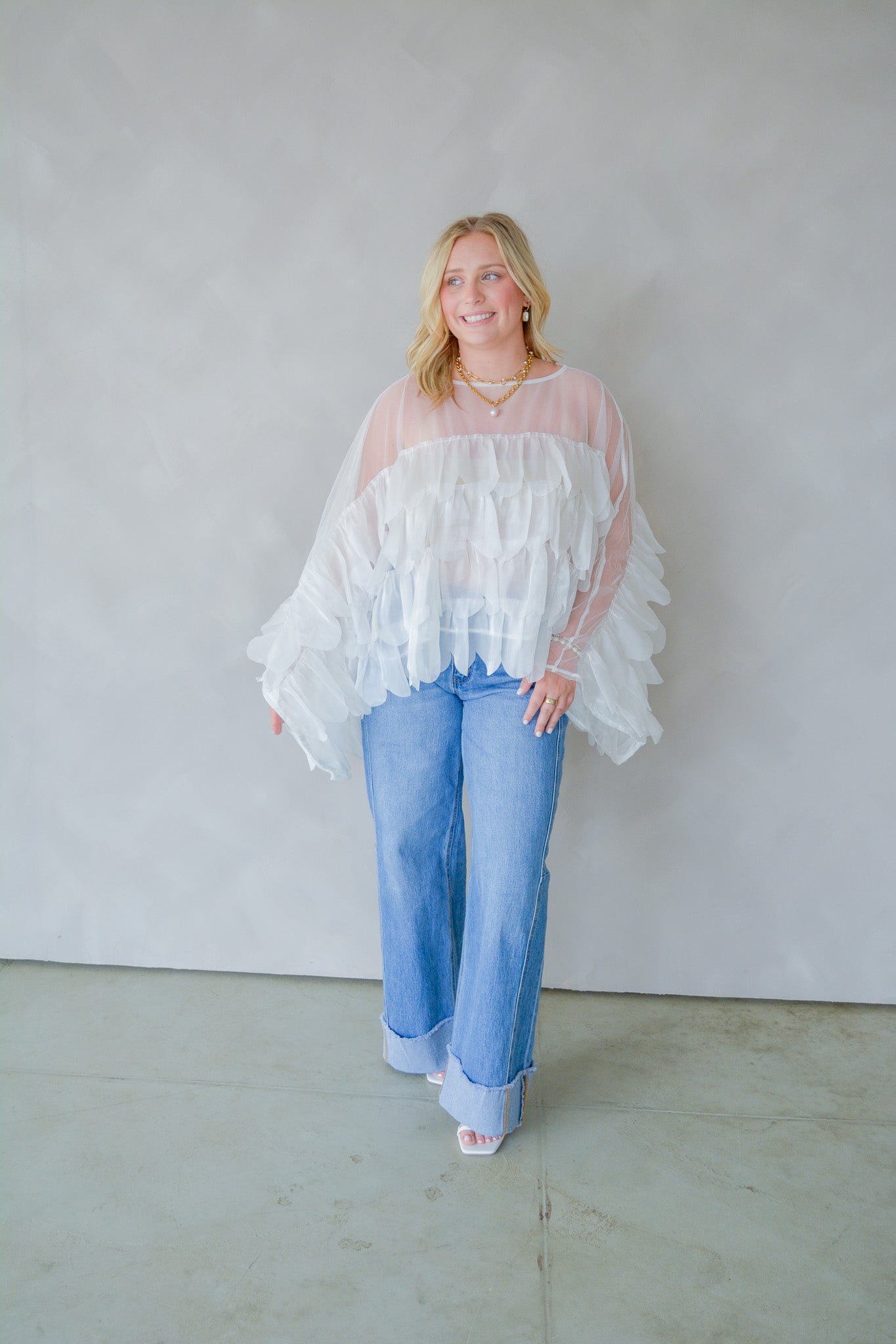 INA Pure Romance Ruffle Top displayed on a hanger with ruffled neckline and lightweight fabric, perfect for casual or chic outfits.