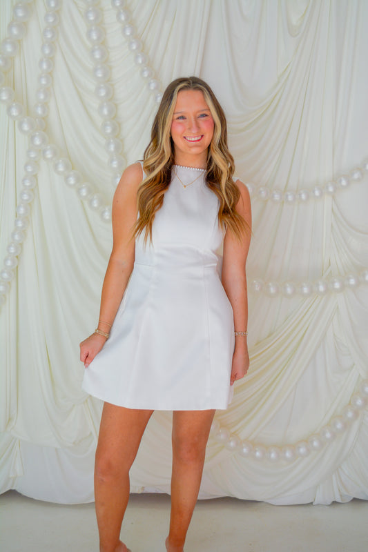 INA The Dream Dress, elegant women’s evening gown with flowing fabric and intricate detailing, shown in a stylish pose.