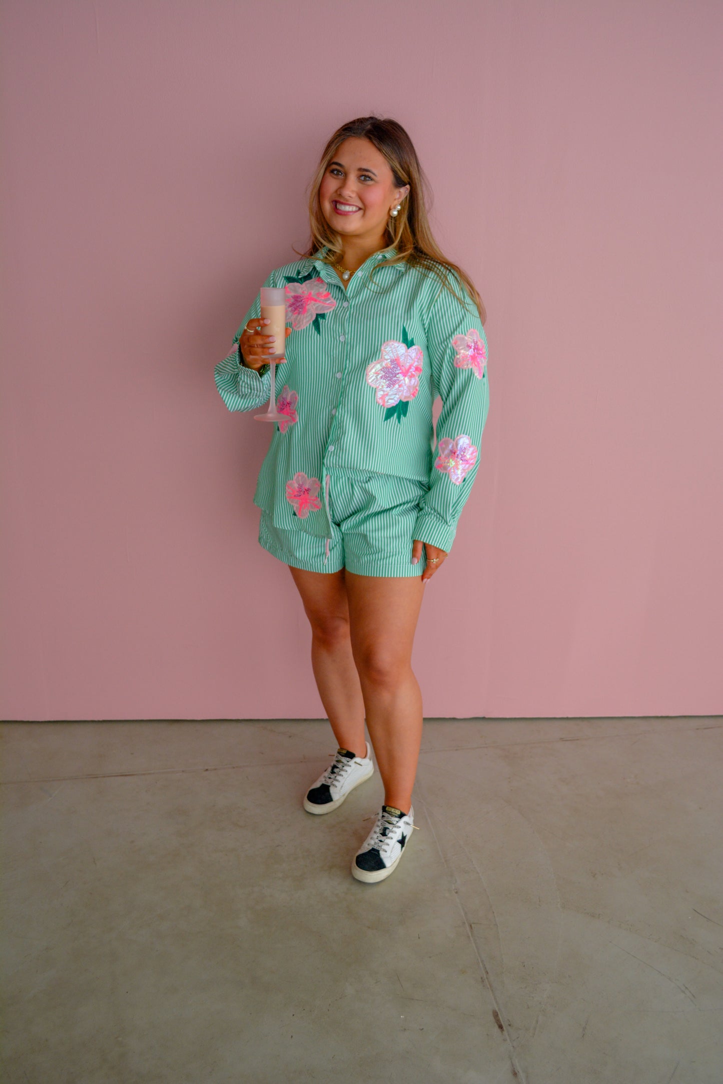 Brianna Cannon Azalea button-down shirt in vibrant floral print, showcased on a hanger against a neutral background.