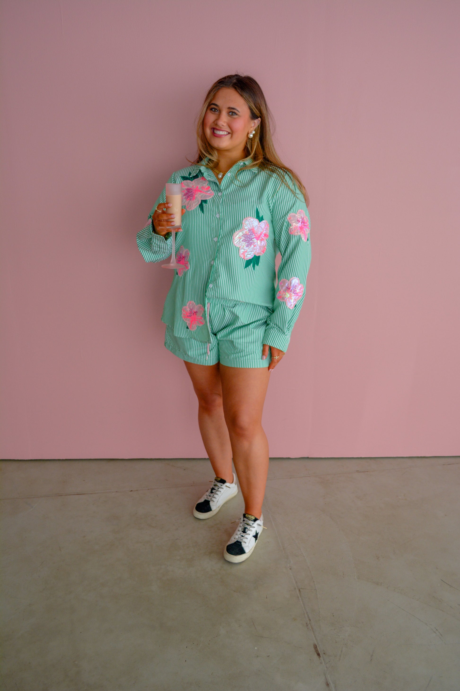 Brianna Cannon Azalea button-down shirt in vibrant floral print, showcased on a hanger against a neutral background.