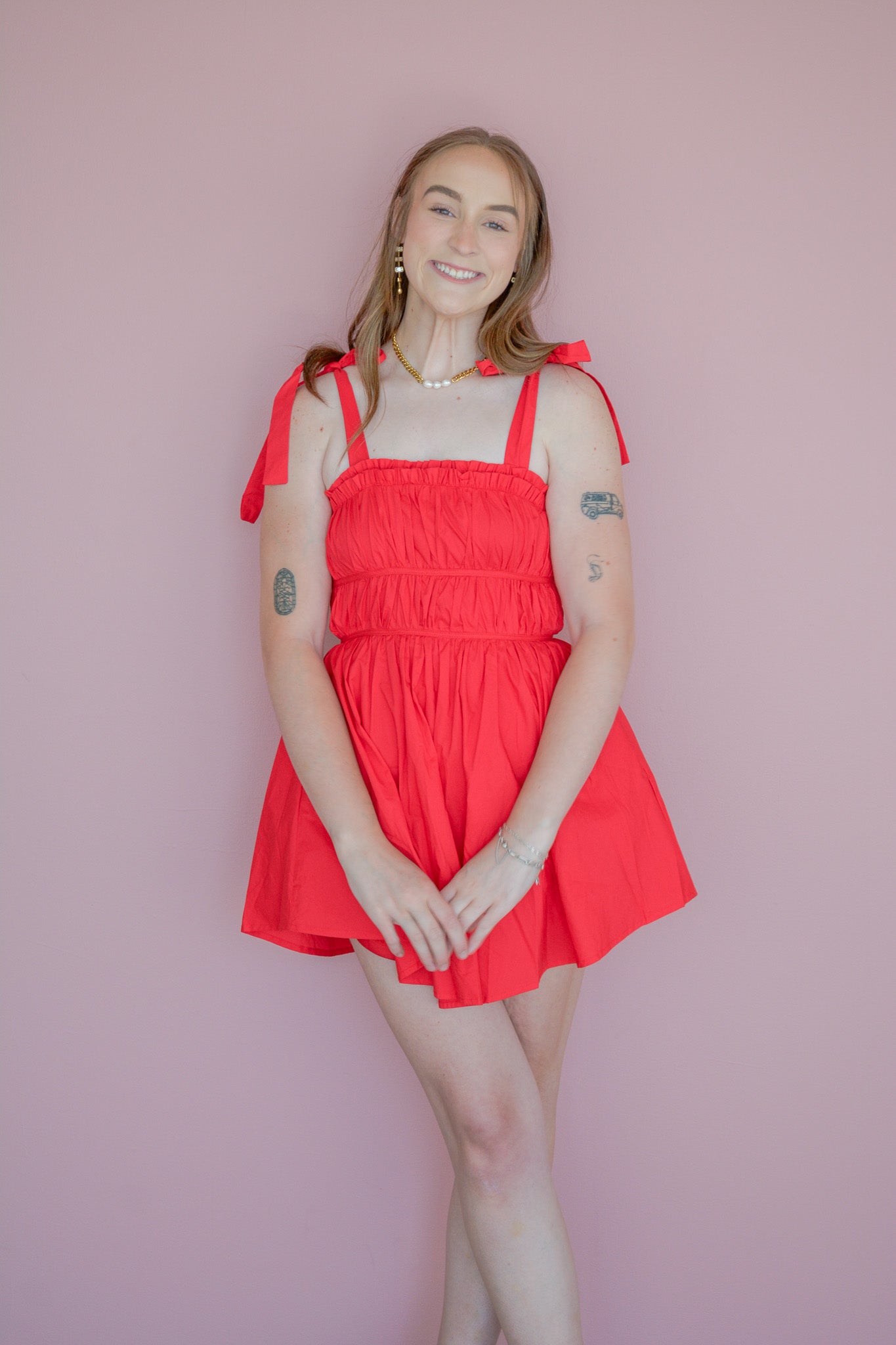 Baby Pink red ruched mini dress displayed on a hanger with close-up details of the fabric and ruching.
