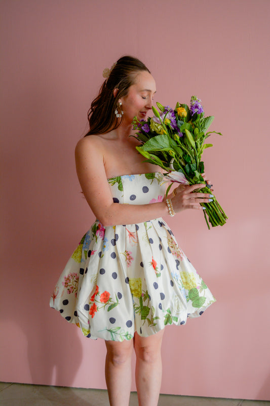 INA Forever Yours Mini Dress in black fabric, featuring a fitted silhouette and stylish neckline, displayed on a hanger.