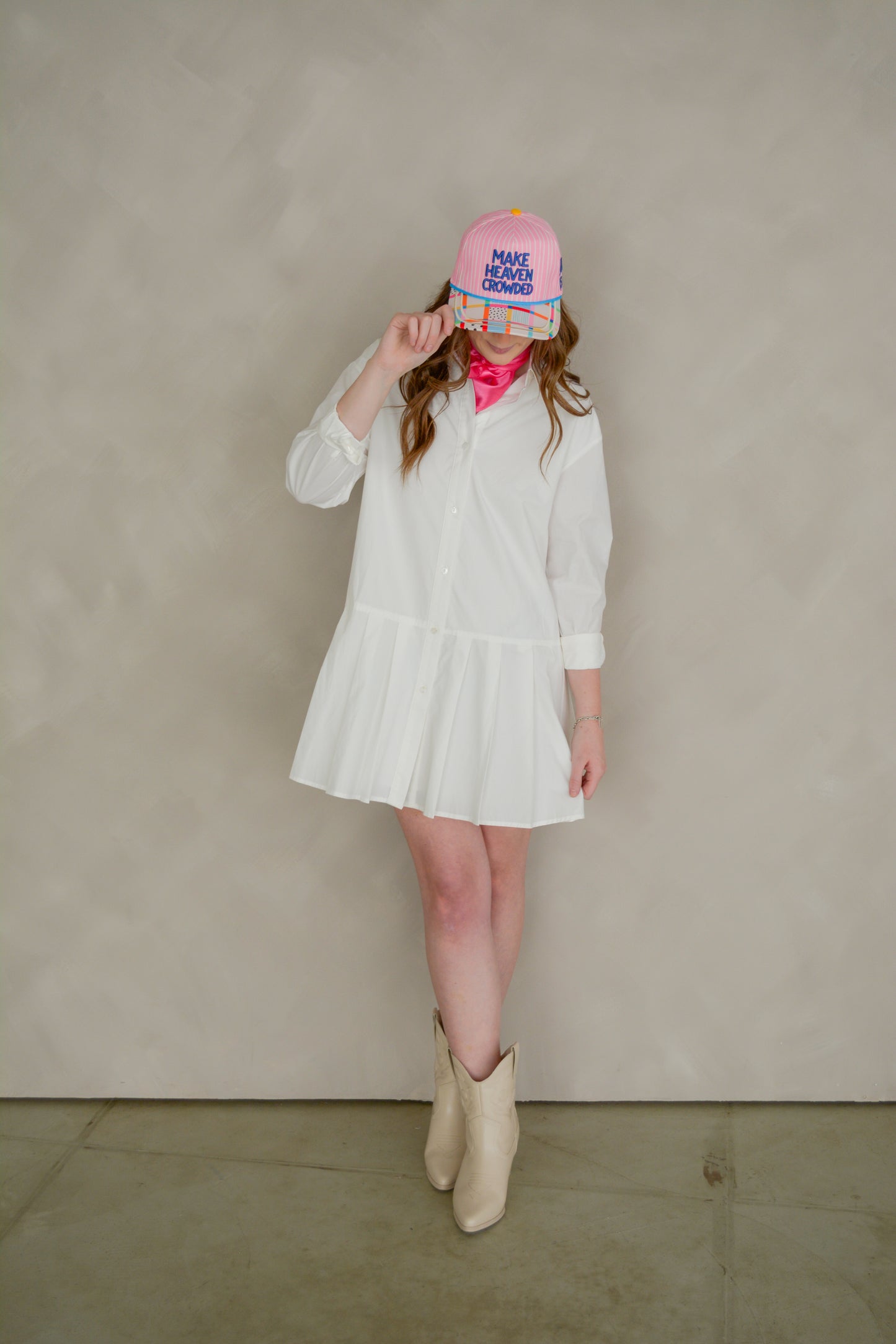 Able Poppy Pleated Shirtdress displayed on a hanger, featuring a flowy, pleated design with a button-up front and collar.