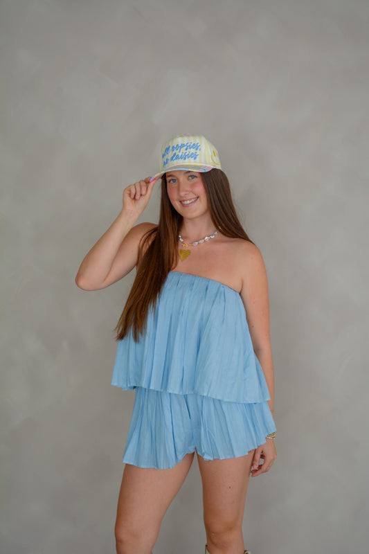 Mable Blended Sunsets Top displayed on a hanger with colorful sunset-inspired fabric pattern.