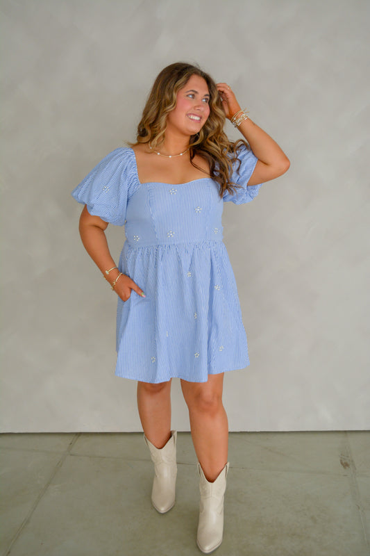 Bluebell Avenue dress by Peach Love California, featuring a stylish floral design and flowing fabric, displayed on a hanger.
