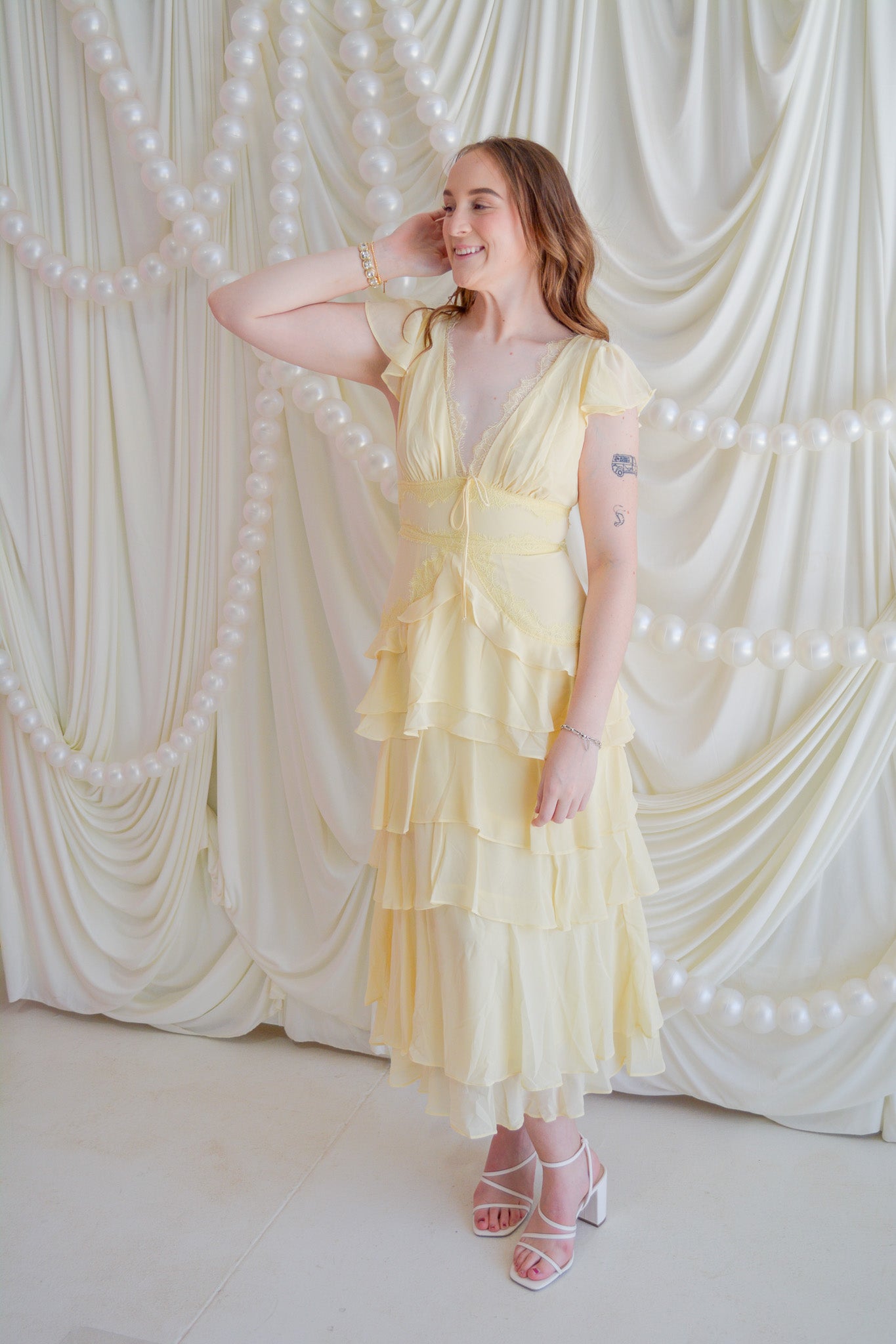 Storia Sunshine Bliss midi dress with floral print, lightweight fabric, and sleeveless design displayed on a hanger.