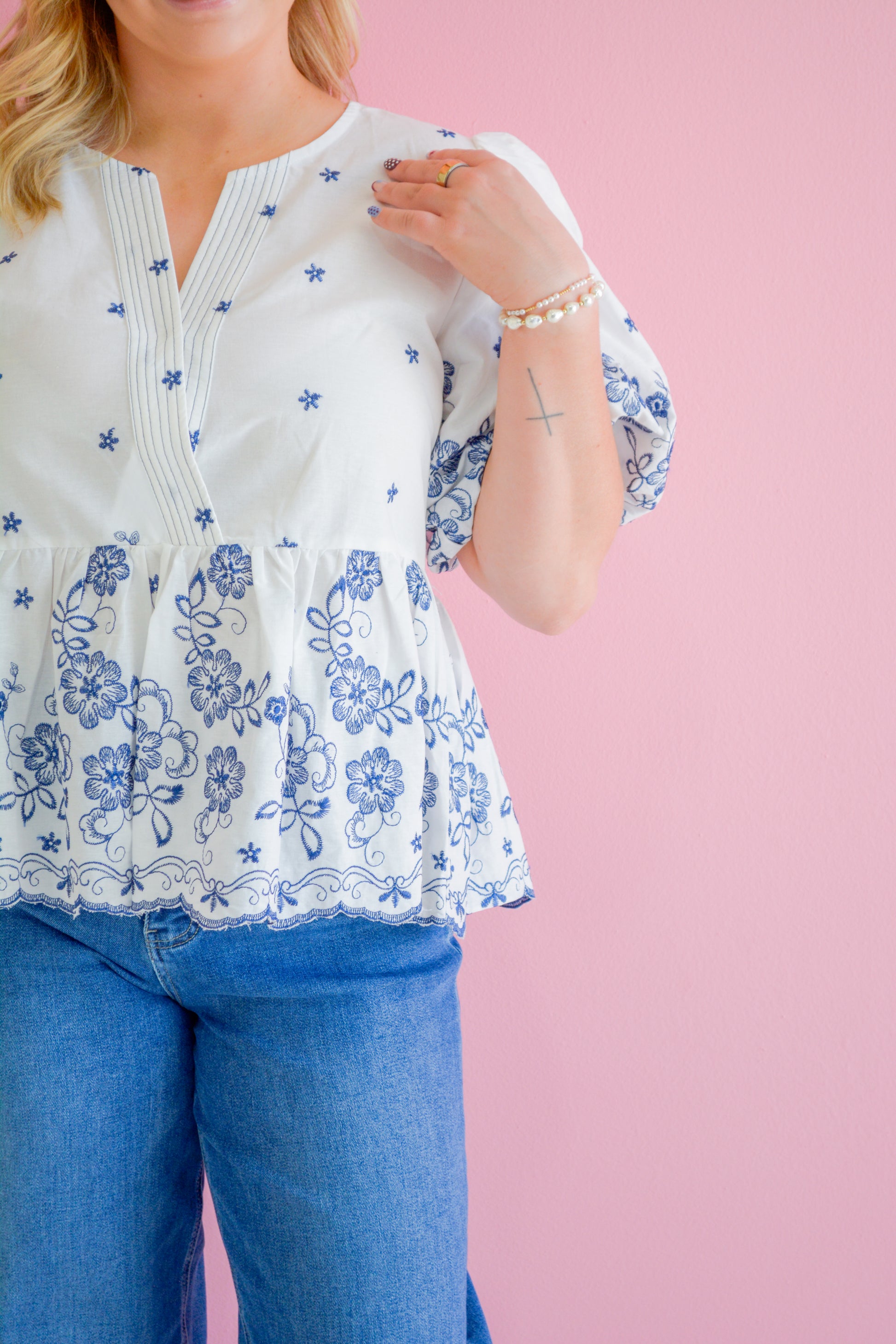 She+Sky Midnight Floral Blouse shown on a hanger with dark background, featuring a flowy fabric and floral pattern.