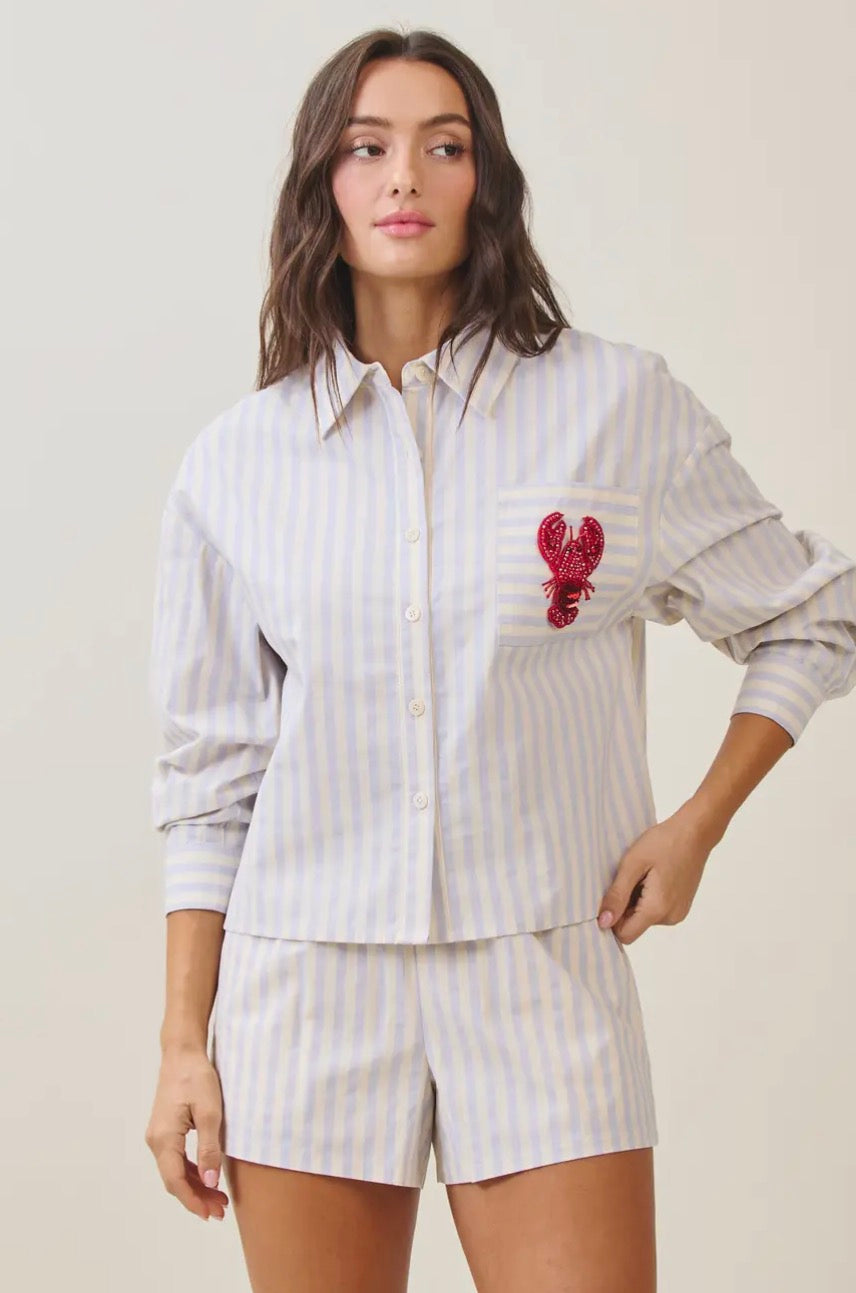 Able Lobster Luxe Linen Top displayed on a hanger, showcasing its relaxed fit and lightweight linen fabric.