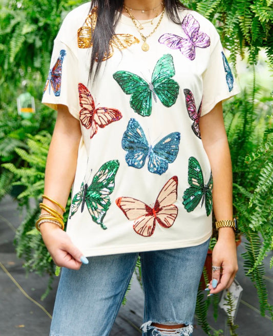 RJM Glitz Butterfly Bliss sequin tee featuring colorful butterfly design and shiny sequin embellishments on soft fabric.