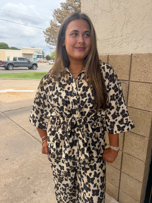 Entro Wildly Yours top displayed on a hanger, featuring a relaxed fit with a stylish neckline and vibrant floral pattern.